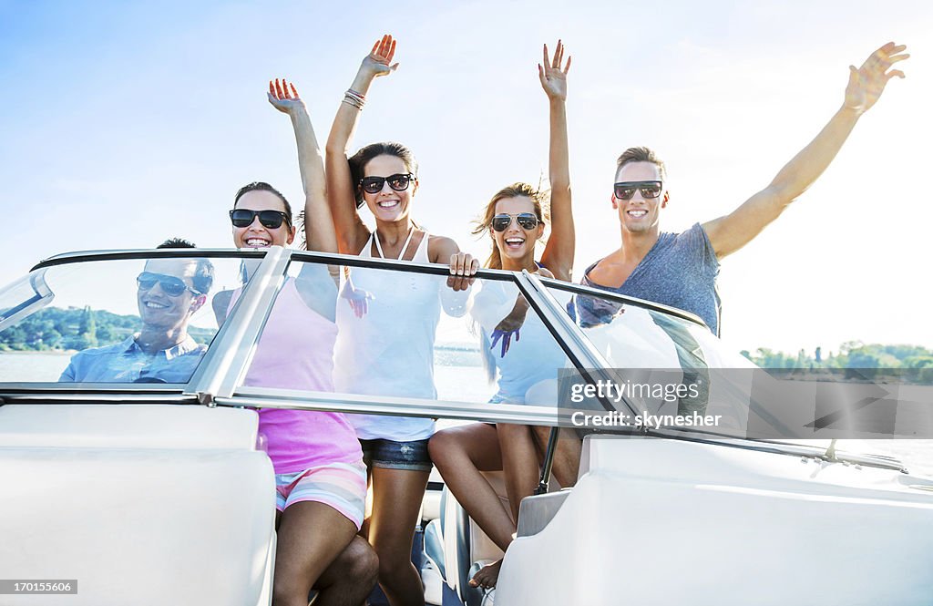 Cheerful group of young people enjoying in speedboat ride.