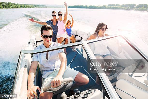 cheerful group of young people enjoying in speedboat ride. - motorboat stock pictures, royalty-free photos & images