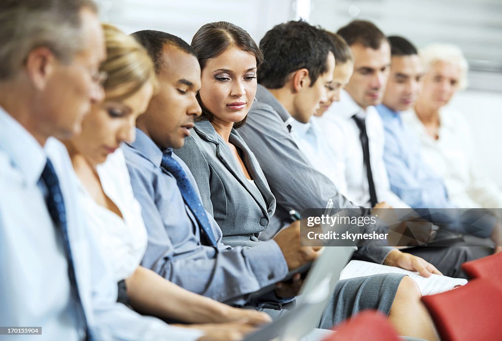 Group of businesspeople sitting in a line.