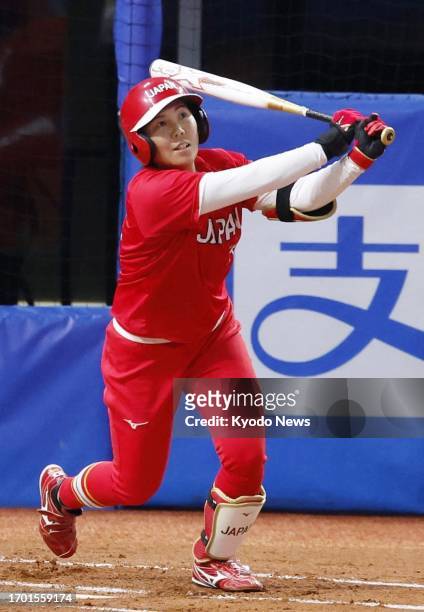 Minori Naito of Japan hits a two-run home run during the first inning of the women's softball gold-medal game against China during the Asian Games in...