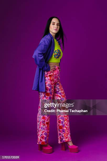 fashionable woman against plain background - floral pattern trousers stock pictures, royalty-free photos & images