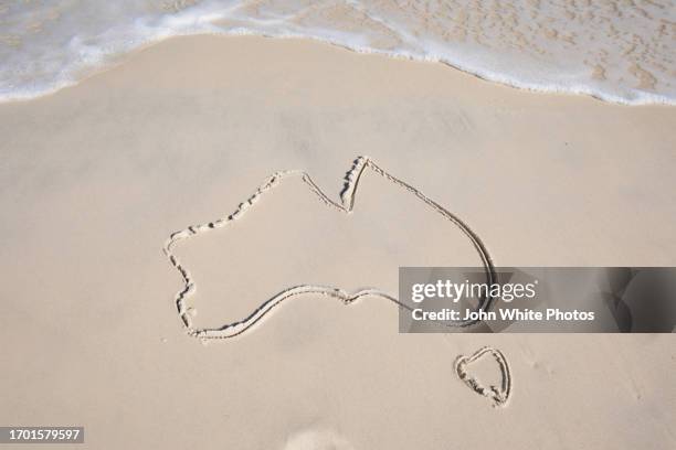 map of australia drawn on a beach. - aussie stock pictures, royalty-free photos & images