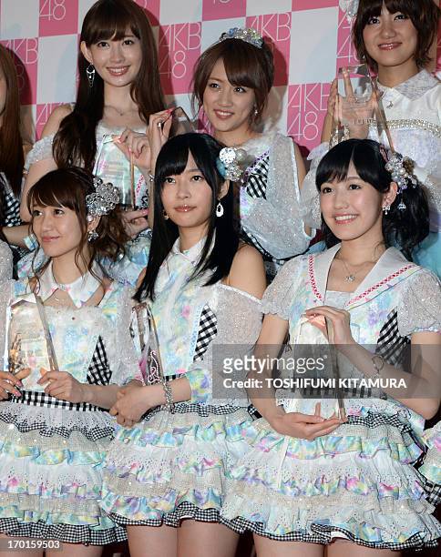 Rino Sashihara of HKT48, one part of Japanese girl pop group AKB48, poses with other selected recording members in a photo session after the group's...