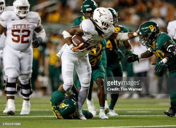 Jonathon Brooks of the Texas Longhorns runs the ball in the second half defended by Caden Jenkins of the Baylor Bears and Devin Lemear at McLane...