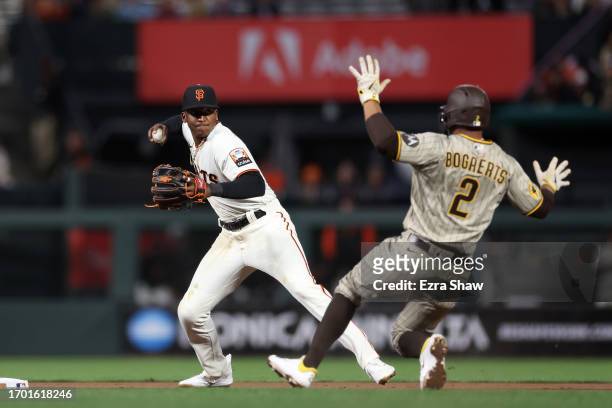 Marco Luciano of the San Francisco Giants turns a double play as Xander Bogaerts of the San Diego Padres is forced out at second base in the eighth...
