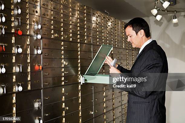 man looking inside safety deposit box - inside of a bank stock pictures, royalty-free photos & images