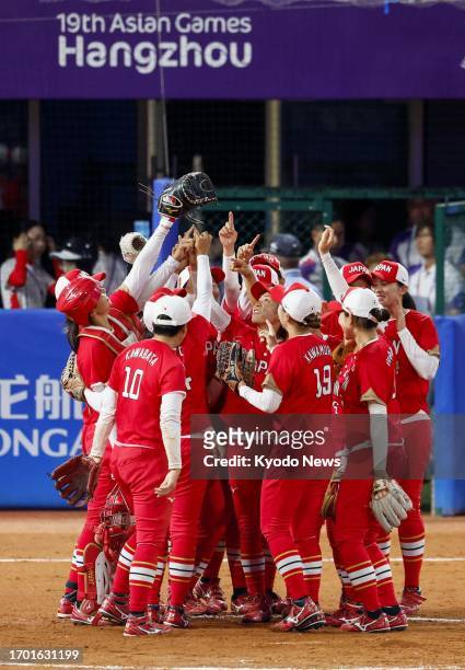 Japan players celebrate after defeating China in the women's softball gold-medal game to complete a six-peat at the Asian Games in Shaoxing, China,...