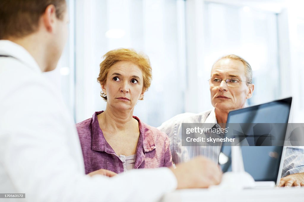 Male doctor with his mature couple patient