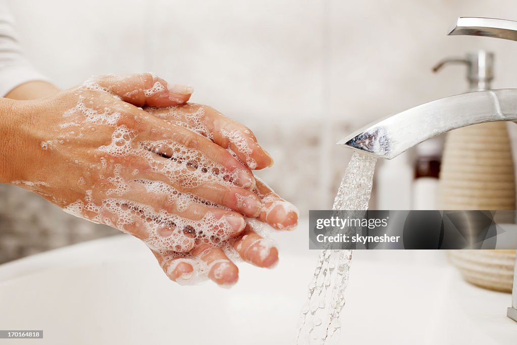 Unrecognizable person washing hands.