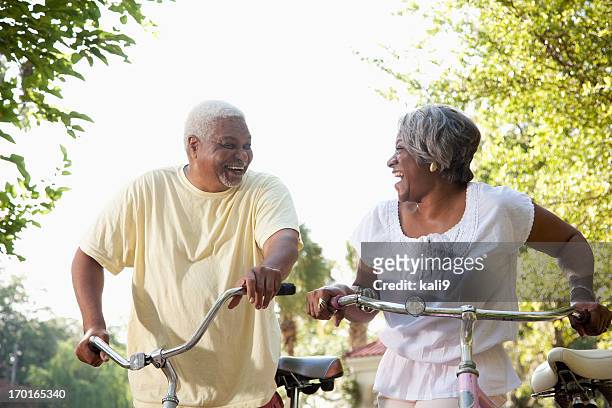 senior african american couple riding bicycles - partnership men bikes stockfoto's en -beelden