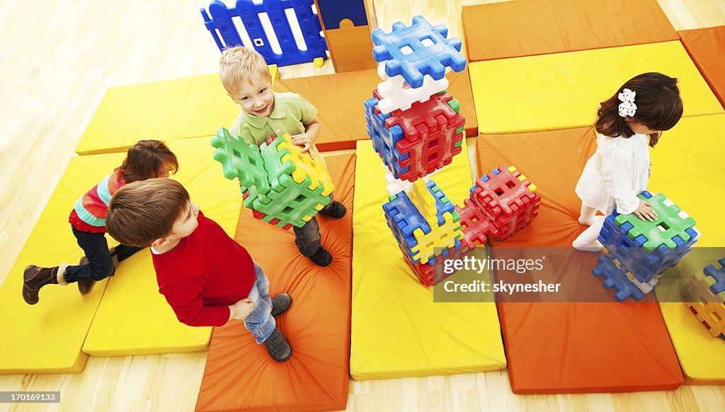 Vista da sopra di bambini impilare blocchi.