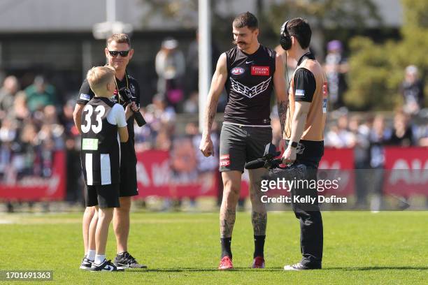 Oleg Markov of the Magpies is interviewed by young supporter during a Collingwood Magpies AFL training session at AIA Centre on September 26, 2023 in...