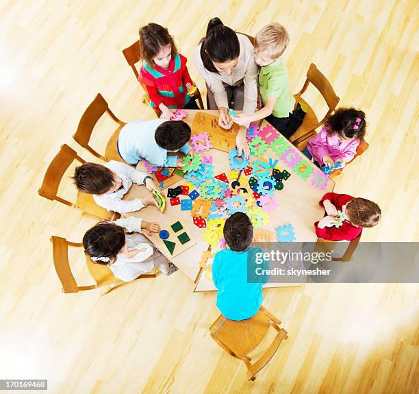 cute group of children with a nursery teacher. - children circle floor stock pictures, royalty-free photos & images