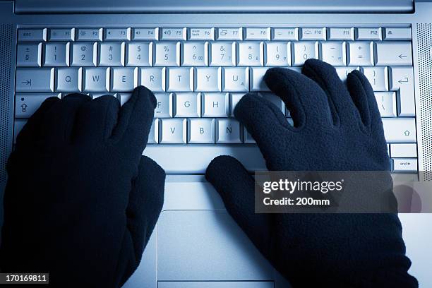 la delincuencia informática hacker trabaja en una computadora portátil - violencia fotografías e imágenes de stock