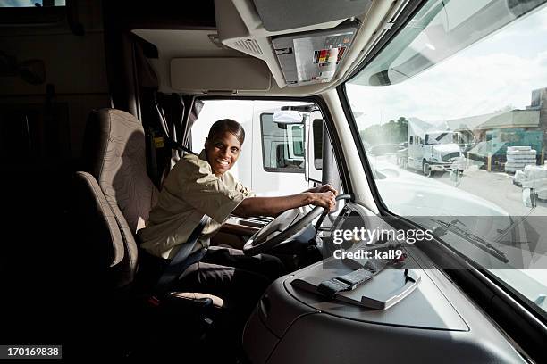 weibliche lkw-fahrer sitzt im cab of semi-truck - female driving stock-fotos und bilder