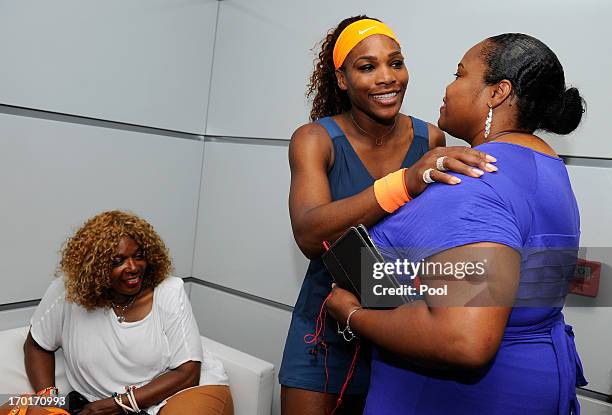 Serena Williams of United States of America hugs Isha Price in her changing room as Oracene Price looks on after her women's singles final match...