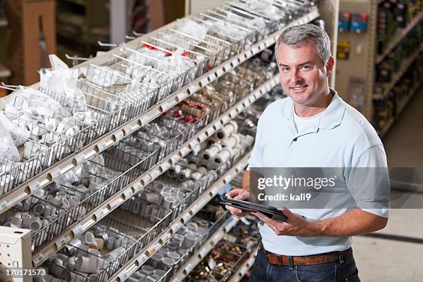 worker in hardware store taking inventory - hardware store stock pictures, royalty-free photos & images
