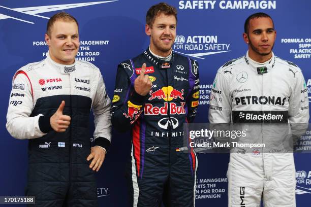 Pole sitter Sebastian Vettel of Germany and Infiniti Red Bull Racing celebrates in parc ferme with second placed Lewis Hamilton of Great Britain and...