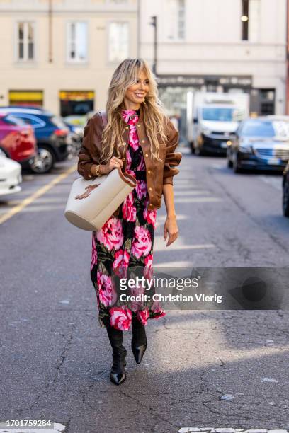 Ekaterina Mamaeva wears dress with floral print Rotate, brown college leather jacket Celine, black boots Acne Studios, creme white brown bag Celine,...