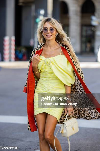 Ekaterina Mamaeva wears yellow dress Rasario, leopard print trench coat Max & Co, white bag Celine, earrings Chanel during the Milan Fashion Week -...