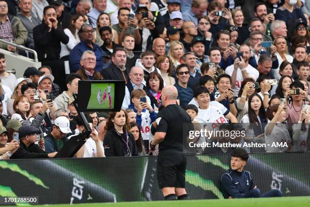 Referee Simon Hooper looks at the VAR monitor before giving a red card to Curtis Jones of Liverpool during the Premier League match between Tottenham...