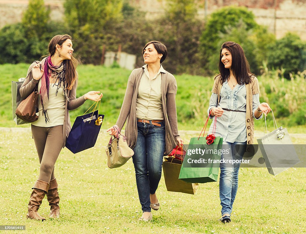 Girls with shopping bag walking on the grass