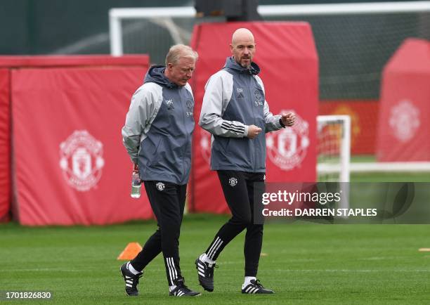 Manchester United's Dutch head coach Erik ten Hag speaks with English assistant Manager Steve McClaren during a training session at the Carrington...