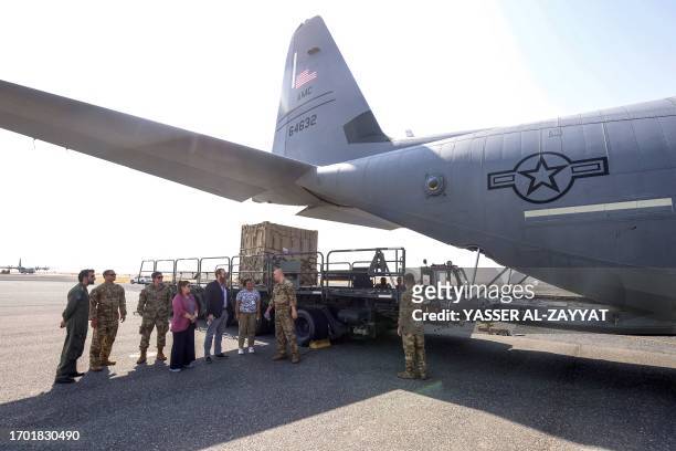 United States Air Force airmen brief journalists by a C-130J Super Hercules military transport aircraft on the tarmac at Ali al-Salem airbase, about...