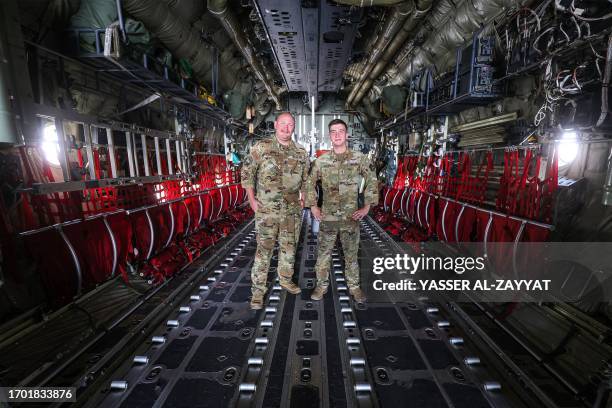 Pilot and loadmaster of the United States Air Force pose for a picture inside a C-130J Super Hercules military transport aircraft at Ali al-Salem...