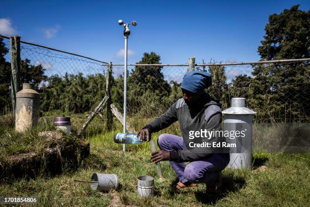 Charles Mwangi, weather station operator checks a device for measuring rainfall at the Meteorological Station on Mount Kenya on September 29, 2023 in...
