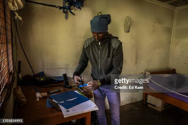Charles Mwangi, weather station operator, cuts paper for a device for measuring hours of sunlight at the Meteorological Station on Mount Kenya on...