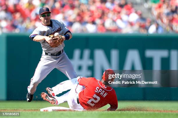 Denard Span of the Washington Nationals is out at second base as Brian Dozier of the Minnesota Twins makes a throw to first base to turn a double...