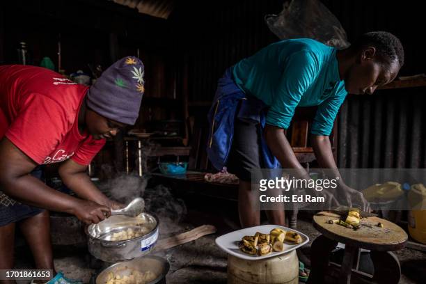 Porter Johana Macharia's family members prepare a meal at his home in Gitinga Village, where 60% of the men work as mountain porters accounting to...