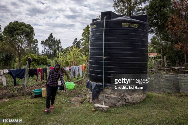 Porter Johana Macharia's family members fetch water and prepare a meal at his home in Gitinga Village, where 60% of the men work as mountain porters...