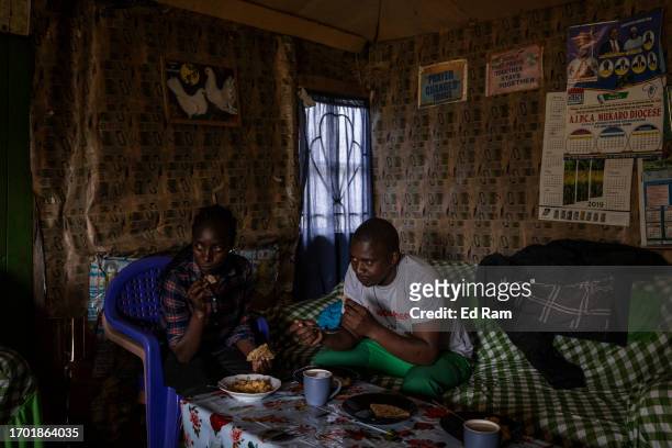 Porter Johana Macharia's daughter and Mountain guide David Wangari eat at Johana Macharia's home in Gitinga Village, where 60% of the men work as...