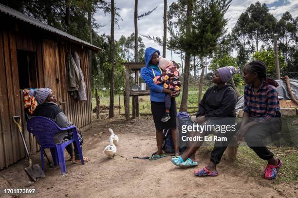 Porter Johana Macharia's family chat at their home in Gitinga Village, where 60% of the men work as mountain porters accounting to locals, on...