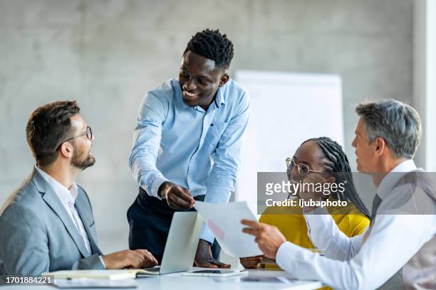 smiling businessman explaining strategy at office - brand advocacy stock pictures, royalty-free photos & images