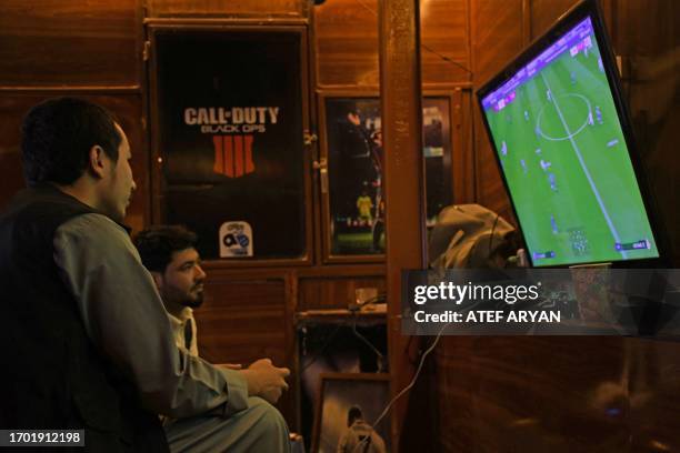 Afghan men play soccer on PlayStation 4 in Pul-e-Khumri of Baghlan province on October 2, 2023.