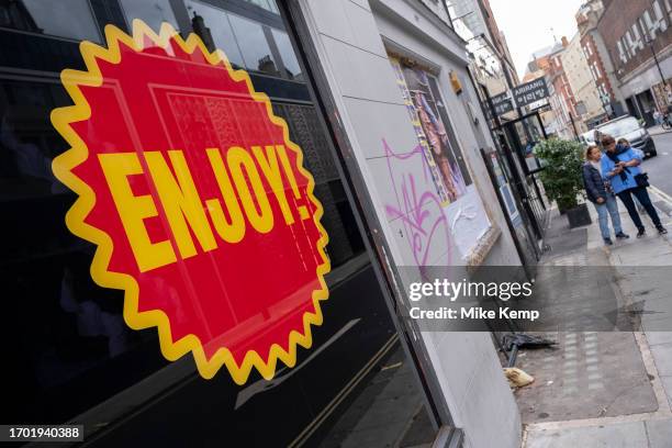 Exterior of a shop with a large sticker which hopes that people 'enjoy!' on 27th September 2023 in London, United Kingdom.