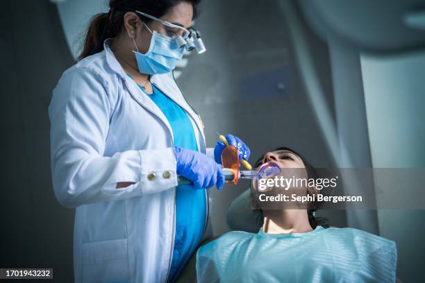 dentist using technology - vulling tandartsapparatuur stockfoto's en -beelden