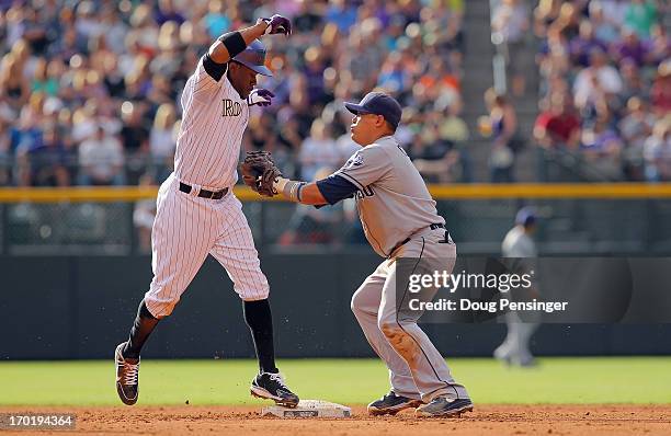 Eric Young Jr. #1 of the Colorado Rockies beats the tag of shortstop Everth Cabrera of the San Diego Padres as he is safe on a double steal allowing...