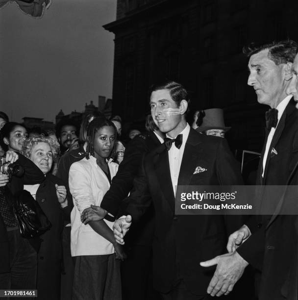 British Royal Charles, Prince of Wales, wearing a tuxedo and bow tie, with plasters on his left cheek, greeting people at an event, Birmingham, West...