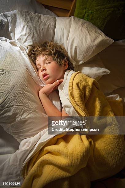 overhead view of boy sleeping in his bed - boy asleep in bed stock-fotos und bilder