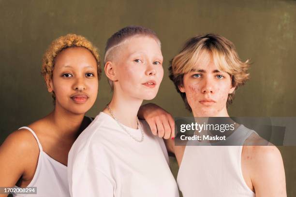 portrait of male and female friends against green background - group of beautiful diverse women stock pictures, royalty-free photos & images