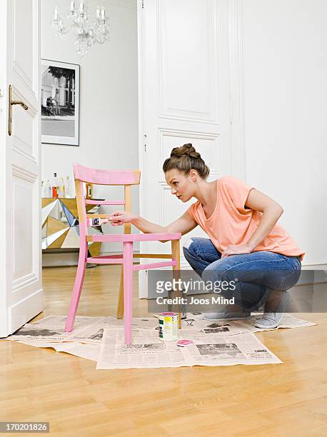 young woman painting wooden chair - rosa germanica foto e immagini stock
