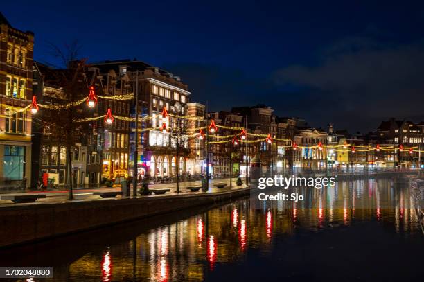 amsterdam beleuchteter kai am rokin im winter - fluss amstel stock-fotos und bilder