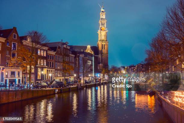 amsterdam prinsengracht with the westerchurch tower at night - amsterdam christmas stock pictures, royalty-free photos & images