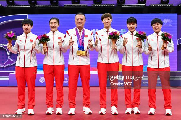 Gold medalists Sun Yingsha, Chen Meng, coach Ma Lin, Wang Manyu, Chen Xingtong and Wang Yidi of Team China pose during the medal ceremony for the...