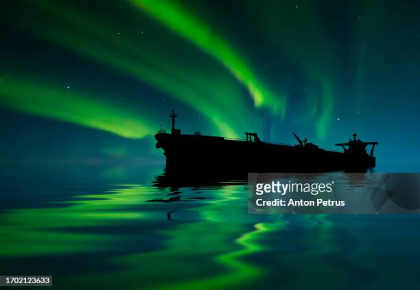 oil tanker at sea under the northern lights - arctic oil stock pictures, royalty-free photos & images
