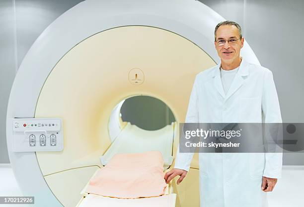 reifer männlicher arzt und magnetresonanztomograph. - pet scan machine stock-fotos und bilder